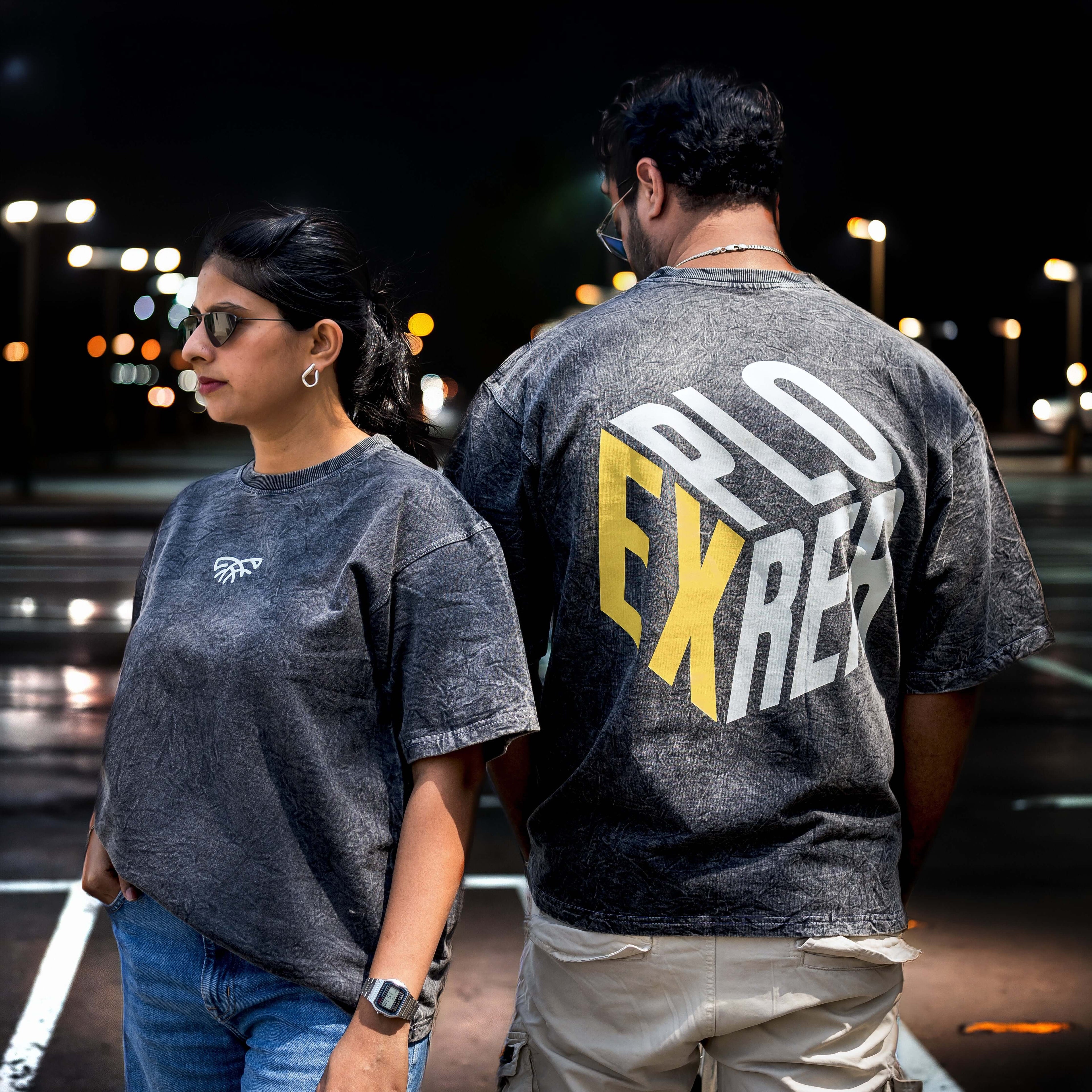 Two people wearing Acid wash boxy fit t-shirt against the dark background