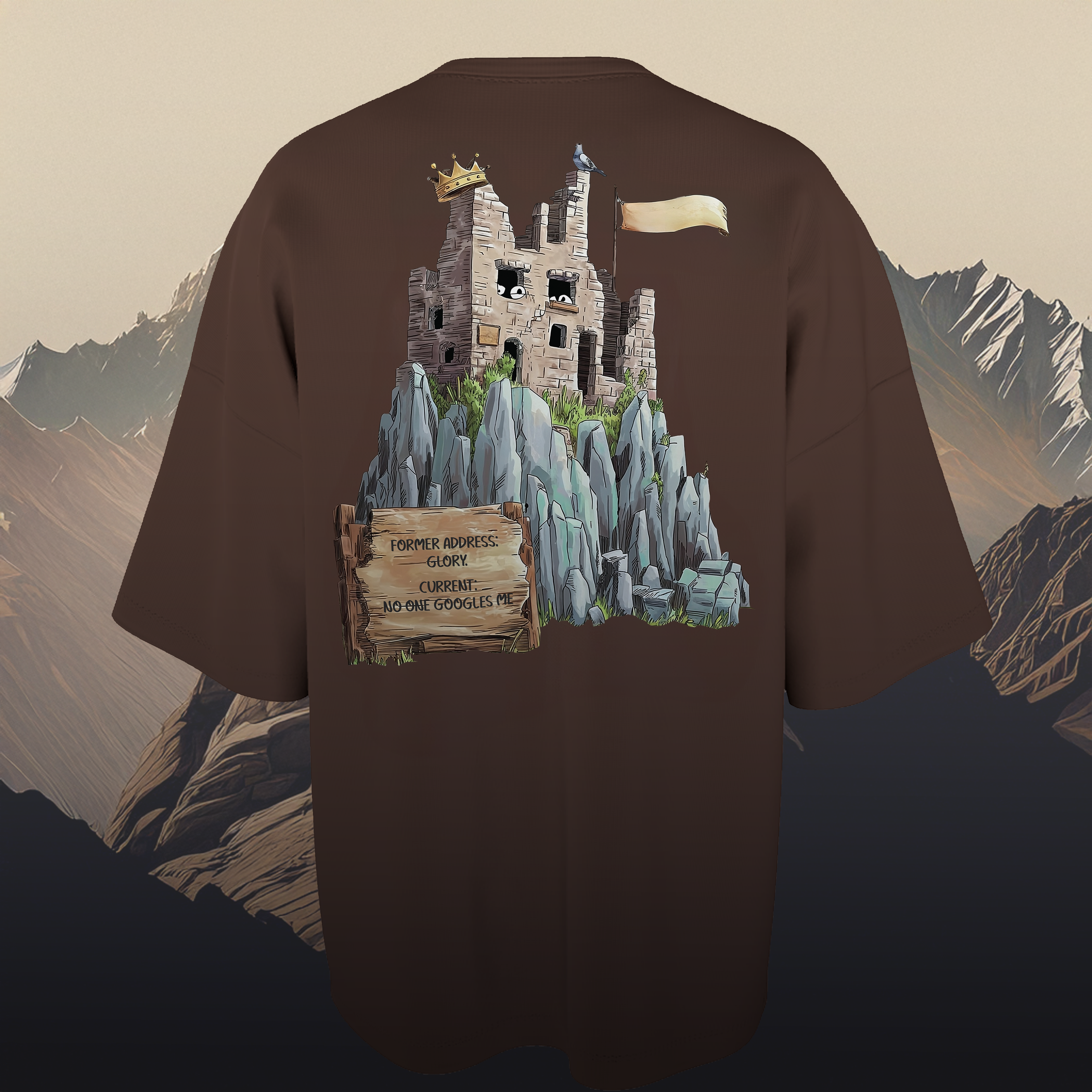 Brown oversized t-shirt with a castle graphic on the back against a mountainous background