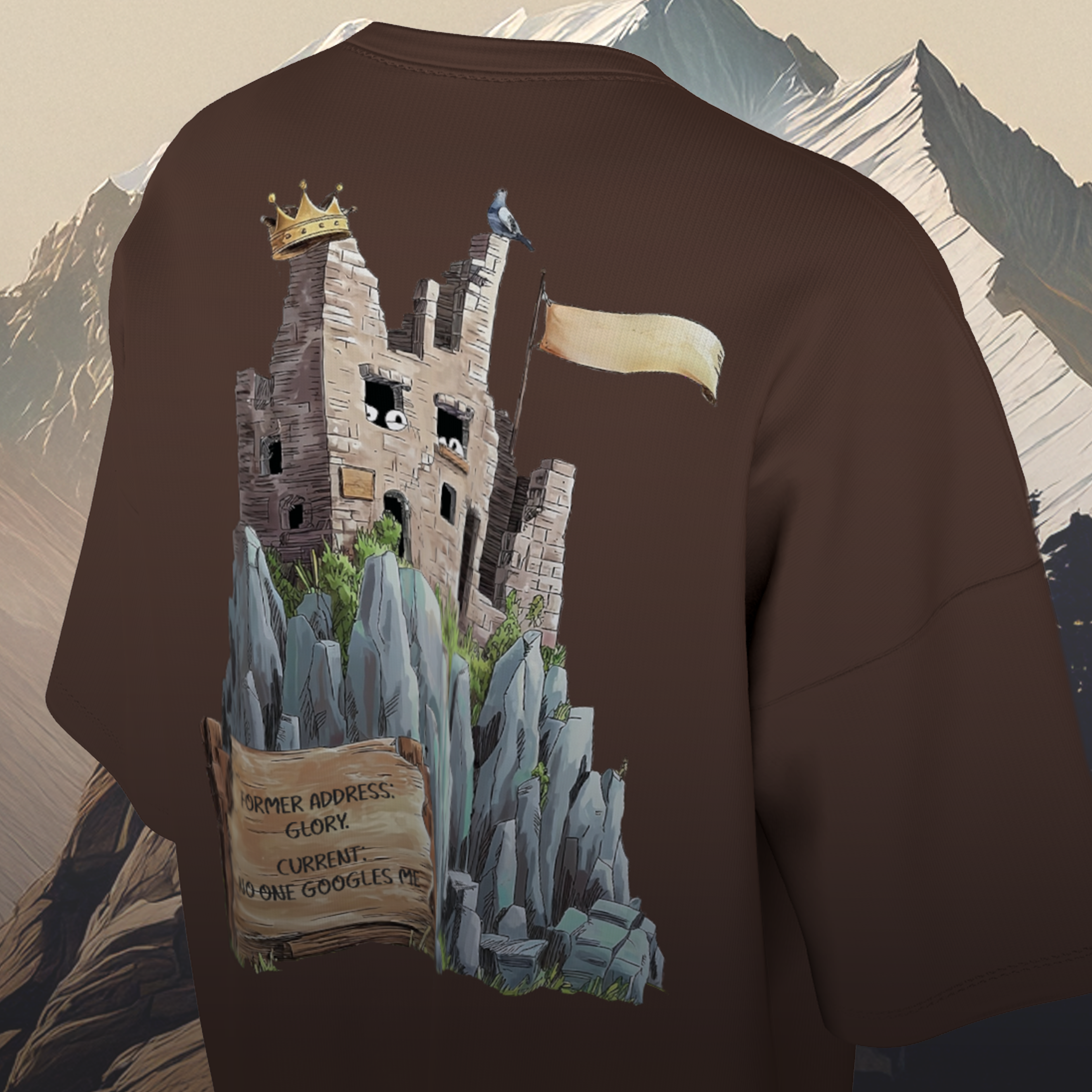 Brown oversized t-shirt with a castle graphic on the back against a mountainous background