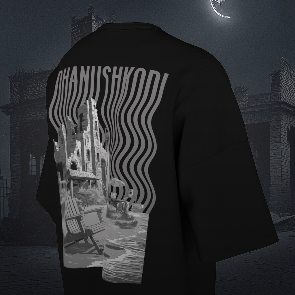 Black oversized t-shirt with a graphic design on the back, featuring a cityscape and text, against a dark, possibly urban background.