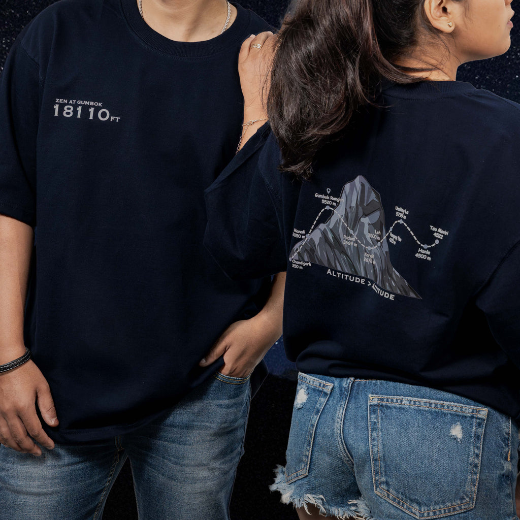 Two people wearing Gumbok Navy blue oversized t-shirts, one with a mountain graphic on the back.