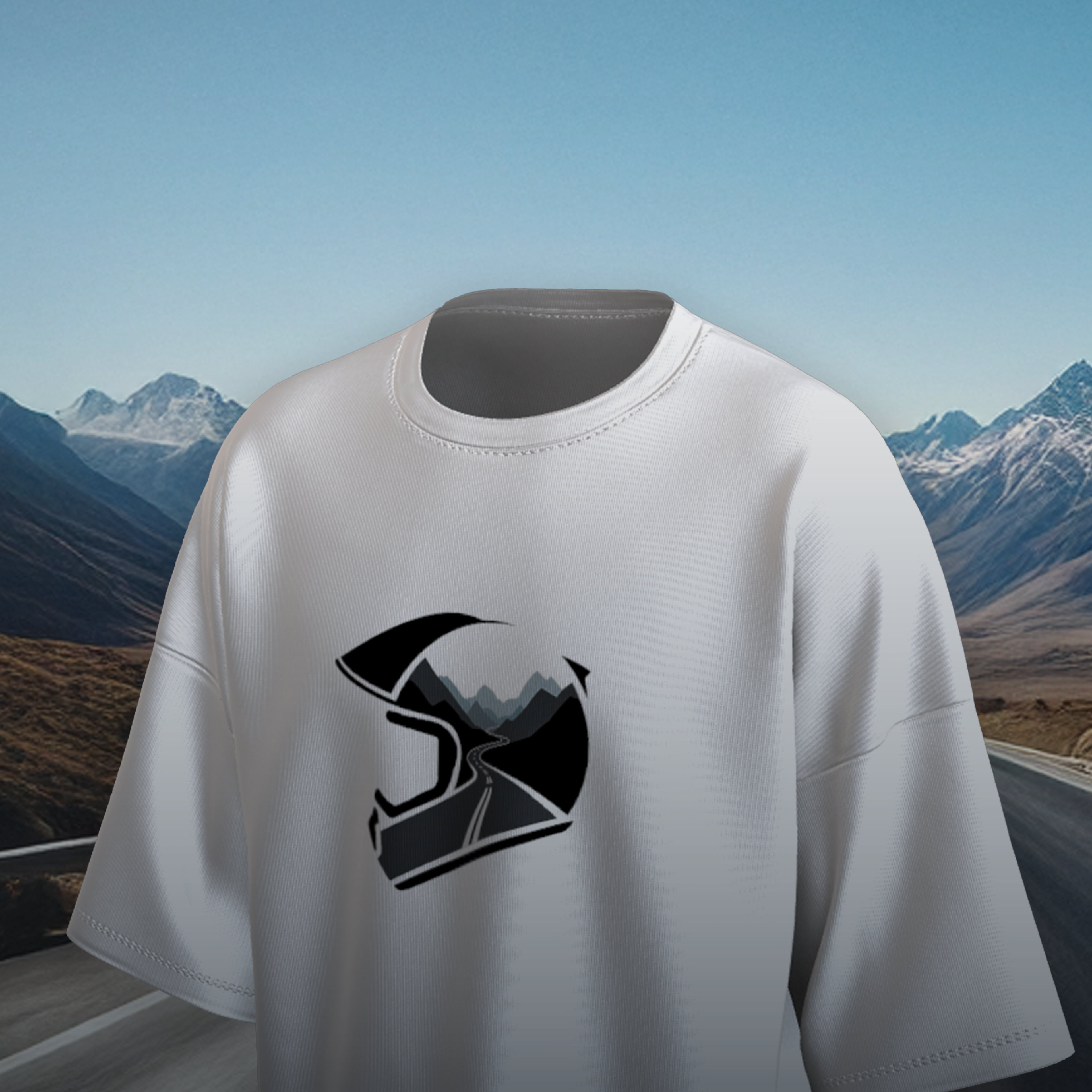 White oversized t-shirt with a black helmet graphic on a scenic mountain road background