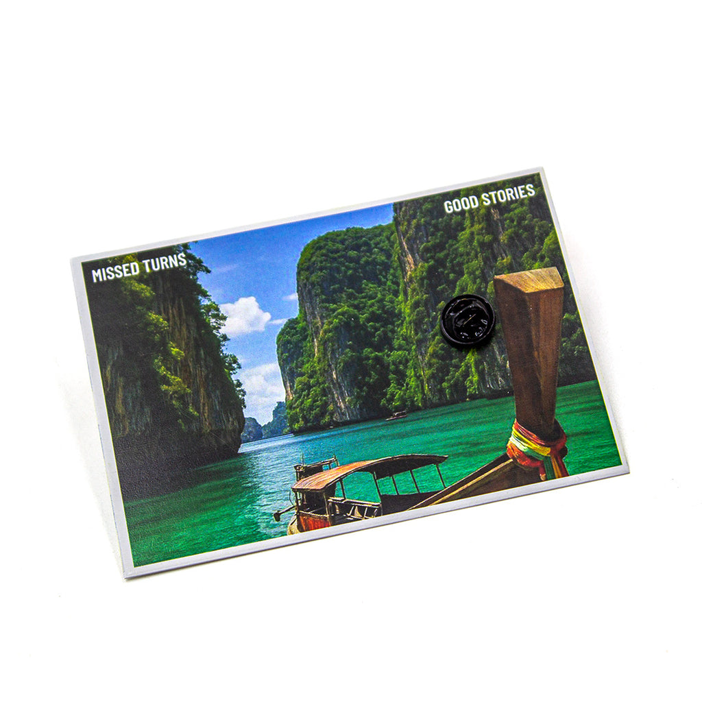 Card with a scenic image of a boat in a tropical location and text 'Missed Turns' and 'Good Stories'.