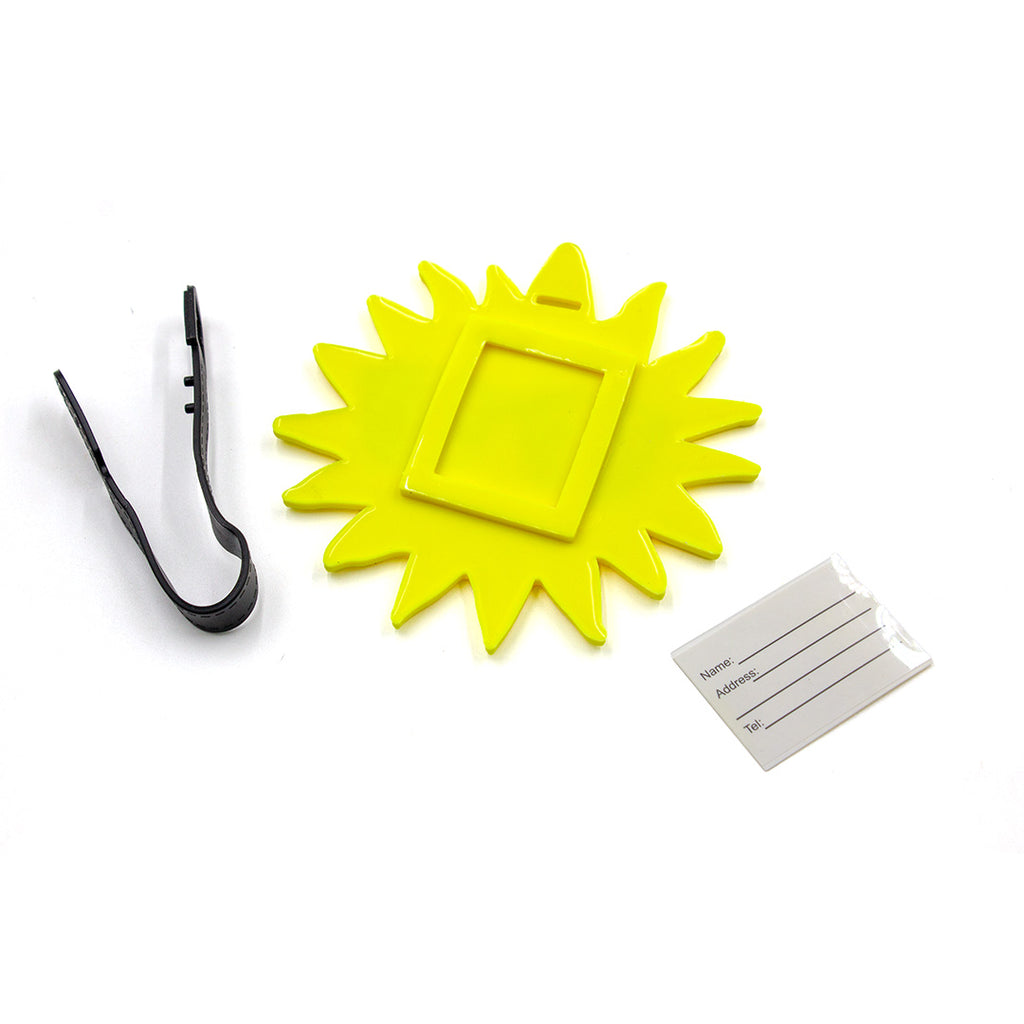 Yellow sun-shaped frame, black hair clip, and white name tag on a white background