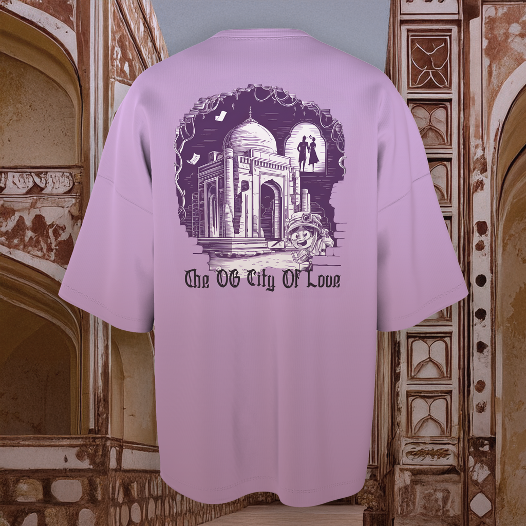 Lavender oversized  t-shirt with architectural design and text 'The OG City Of Love' against a decorative wall background