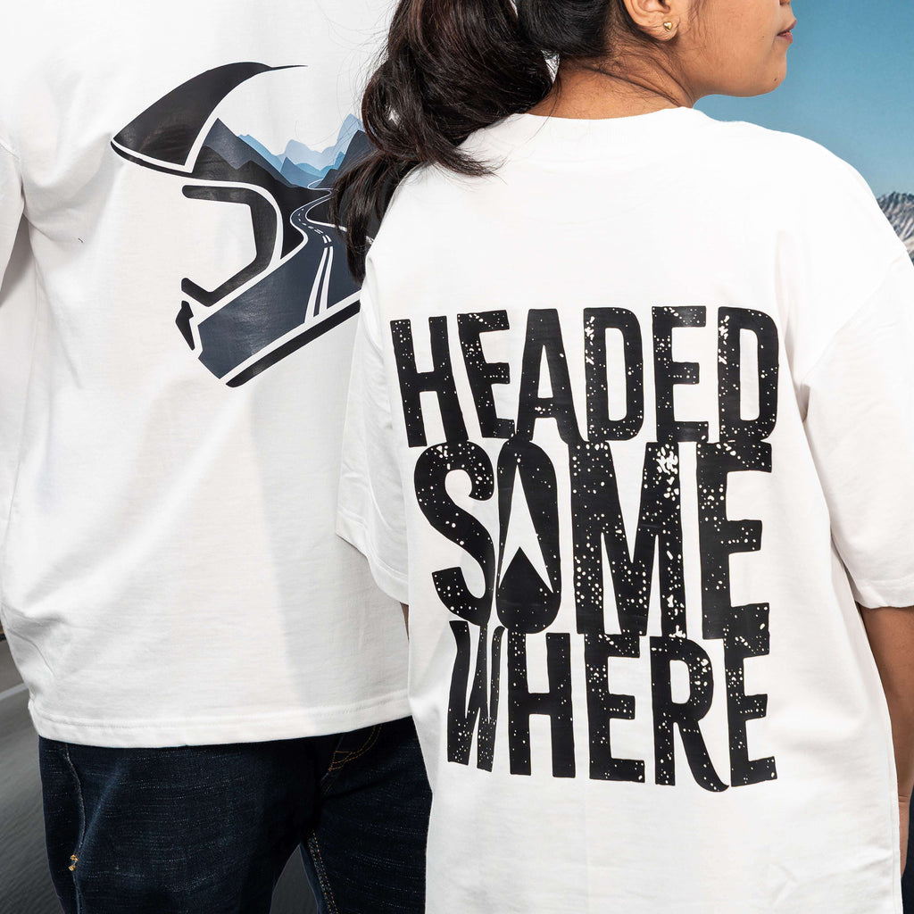 Two people wearing mountain helmet white oversized t-shirts with graphic designs and text.