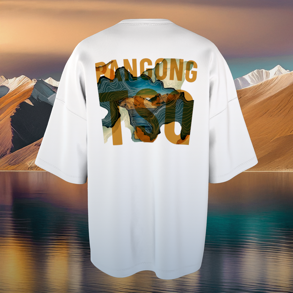 White oversized t-shirt with mountain graphic and text on a scenic background
