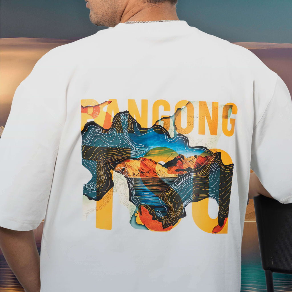 Person wearing a Pangong Tso white oversized t-shirt with colourful graphic design on the back