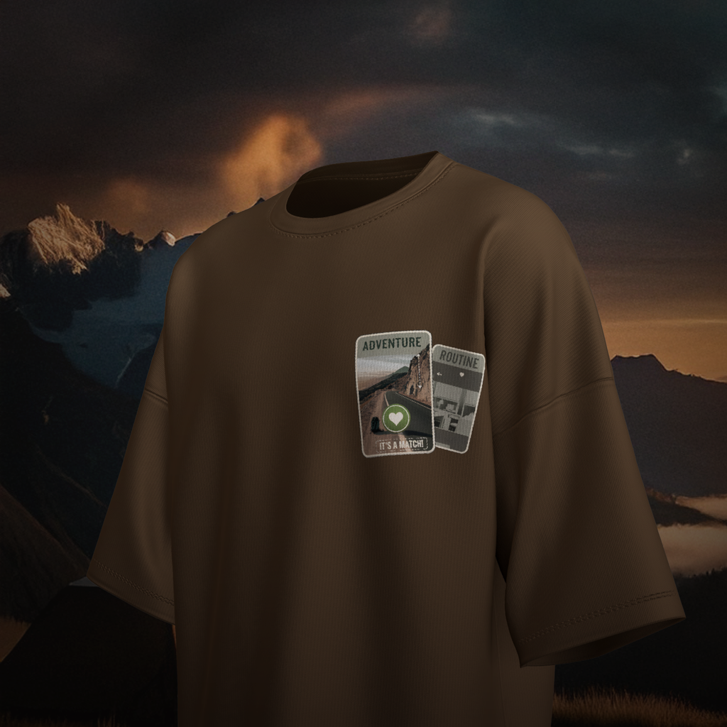 Brown oversized  t-shirt with 'Adventure & Routine' patches against a mountainous landscape