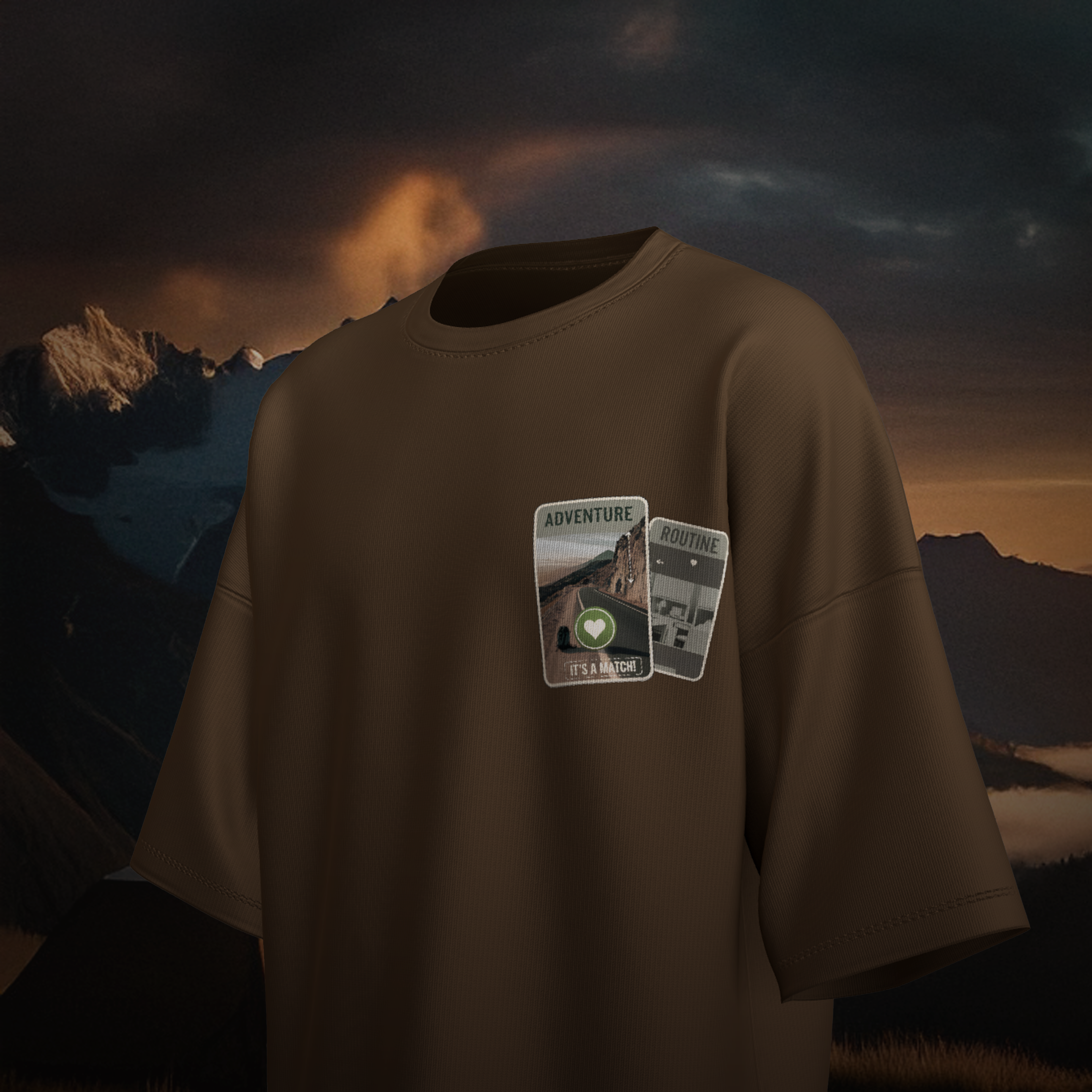 Brown oversized  t-shirt with 'Adventure & Routine' patches against a mountainous landscape