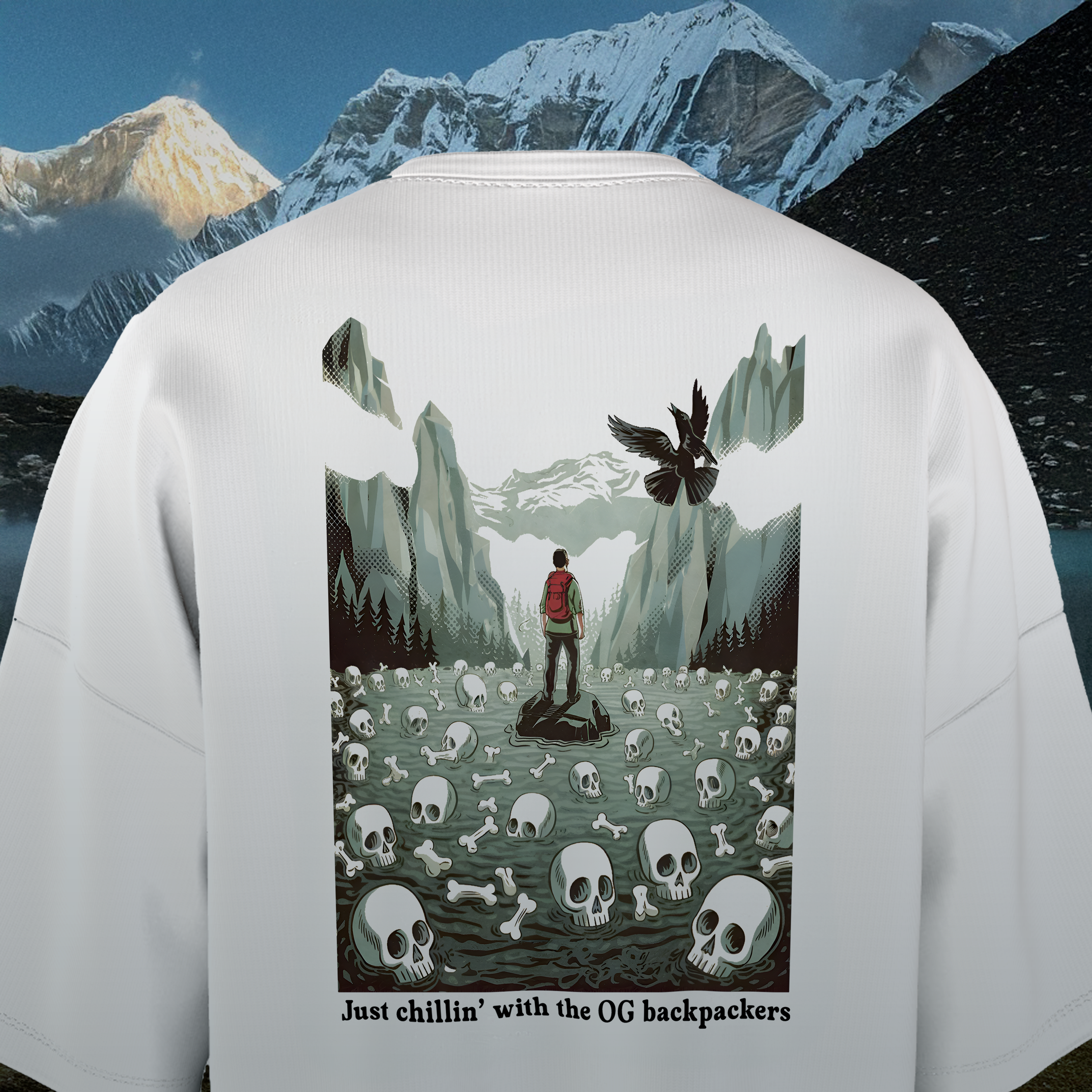 Back of a white oversized t-shirt with a graphic design of a person with a backpack in a mountainous landscape with skulls and bones.