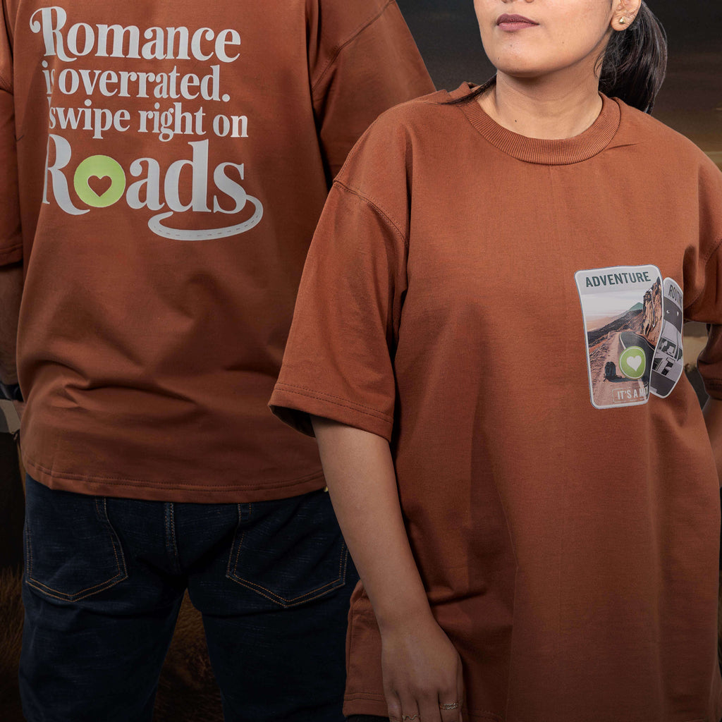 Two people wearing tinder for roads brown oversized t-shirts with text and graphics.