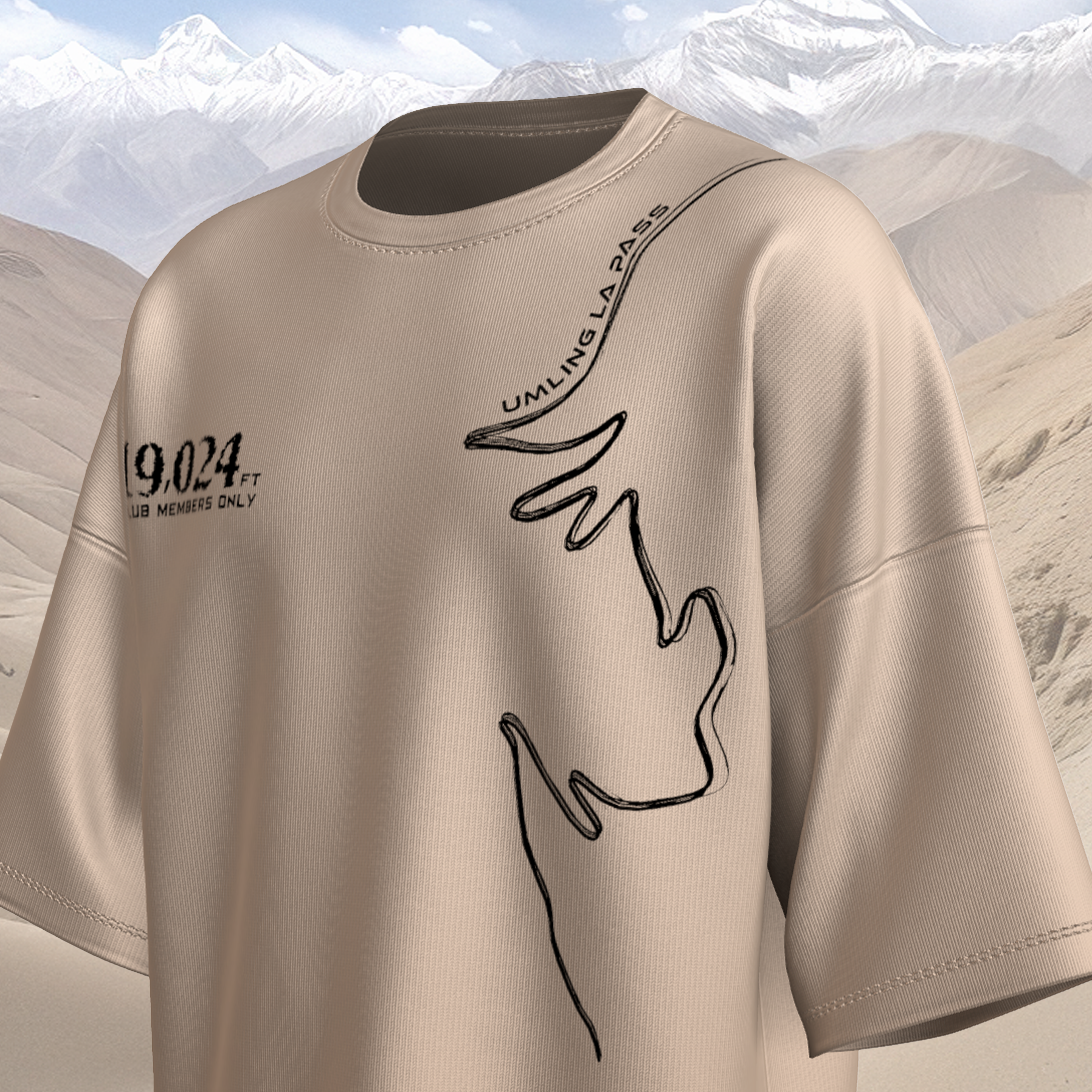 Beige oversized t-shirt with black graphics and text against a mountainous background