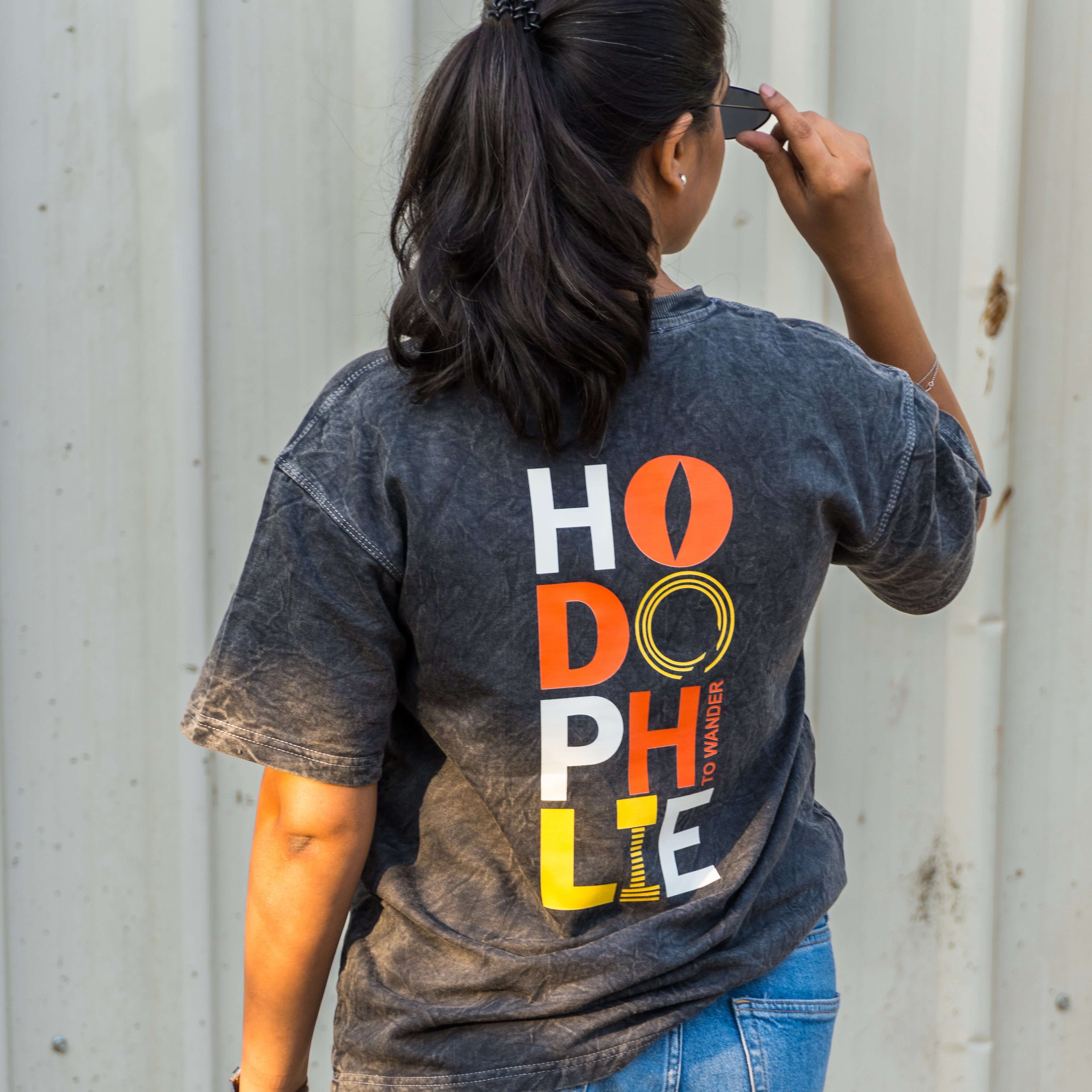 Person wearing acid wash t-shirt with hodophile text on the back, standing against a plain background.