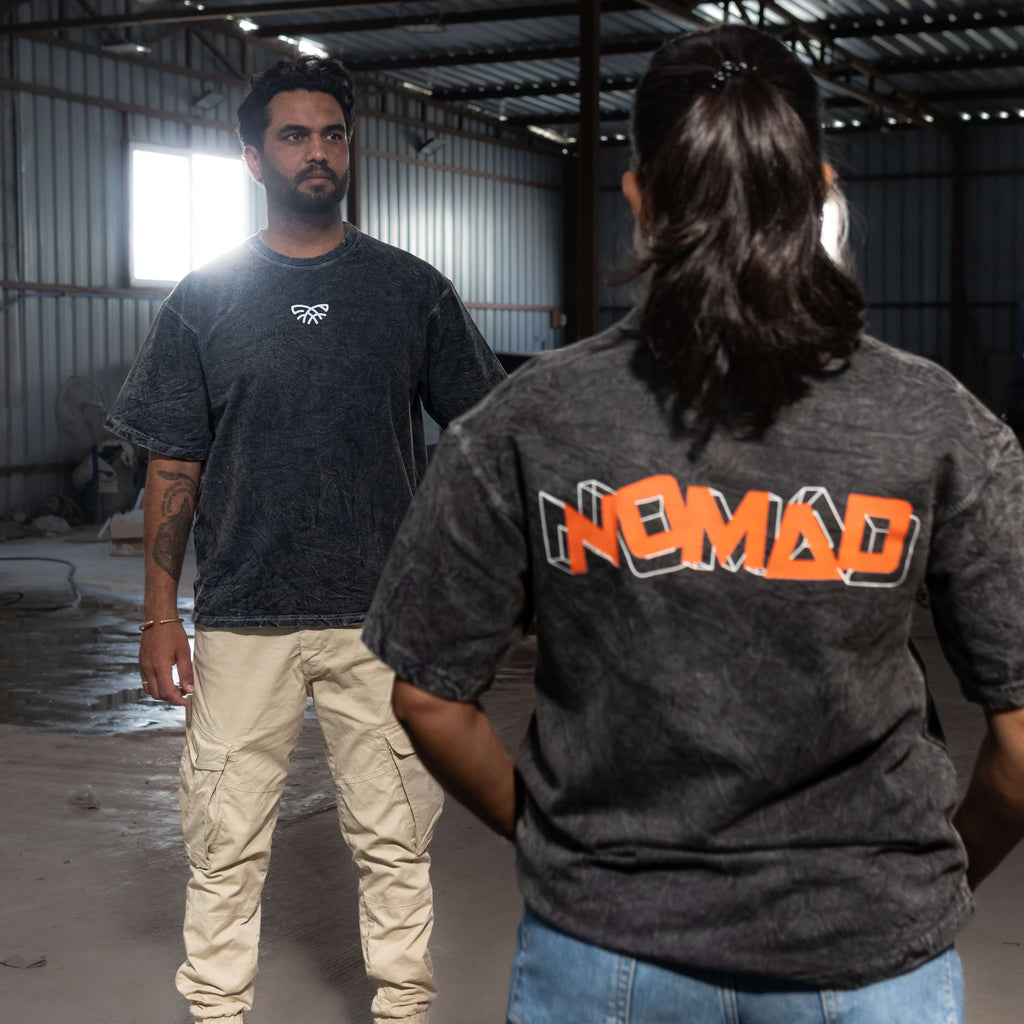 Two people wearing acid wash t-shirts in an industrial setting