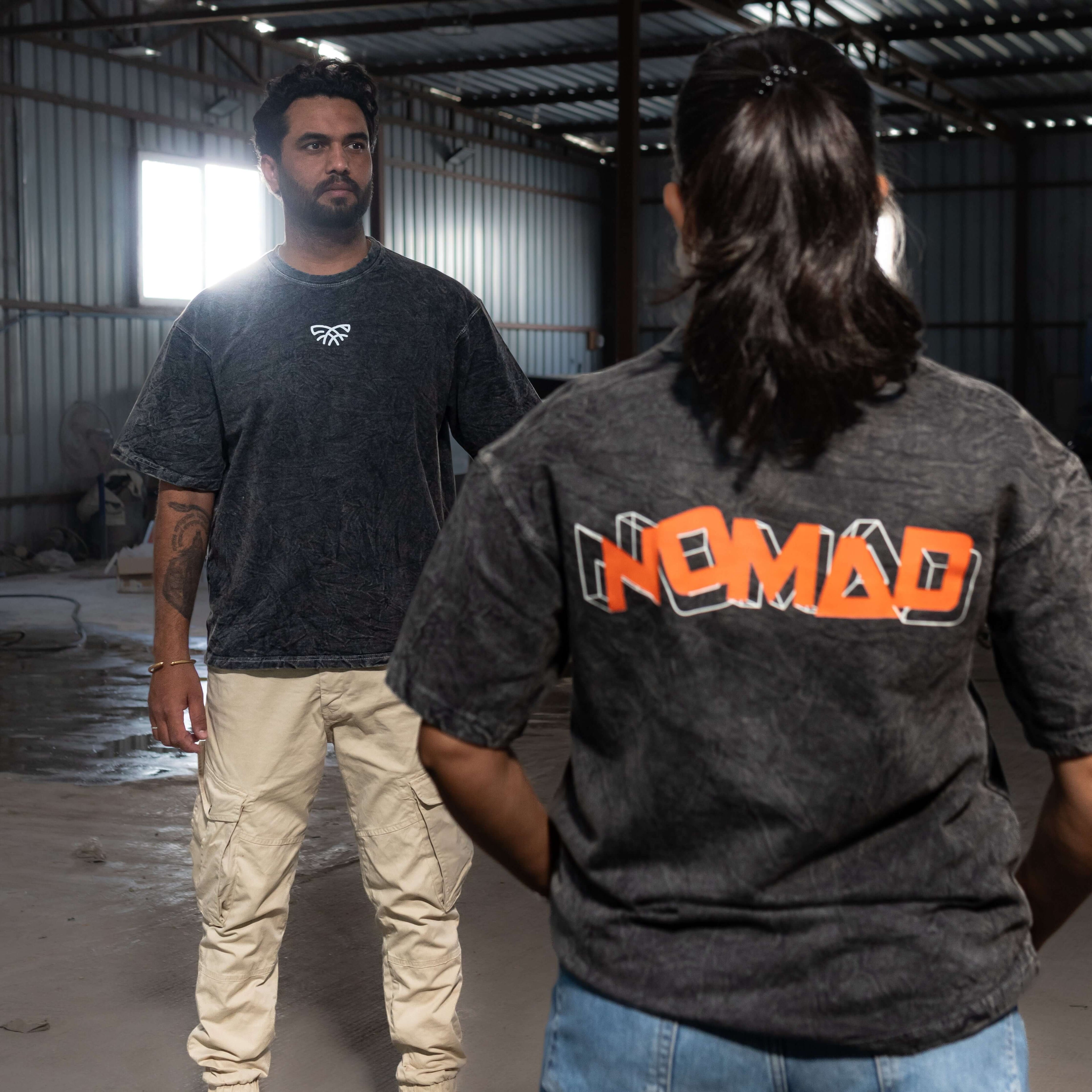 Two people wearing acid wash t-shirts in an industrial setting