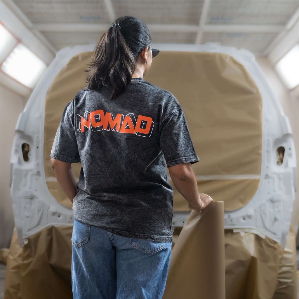 Women wearing a 'Nomad' acid wash t-shirt in a workshop setting