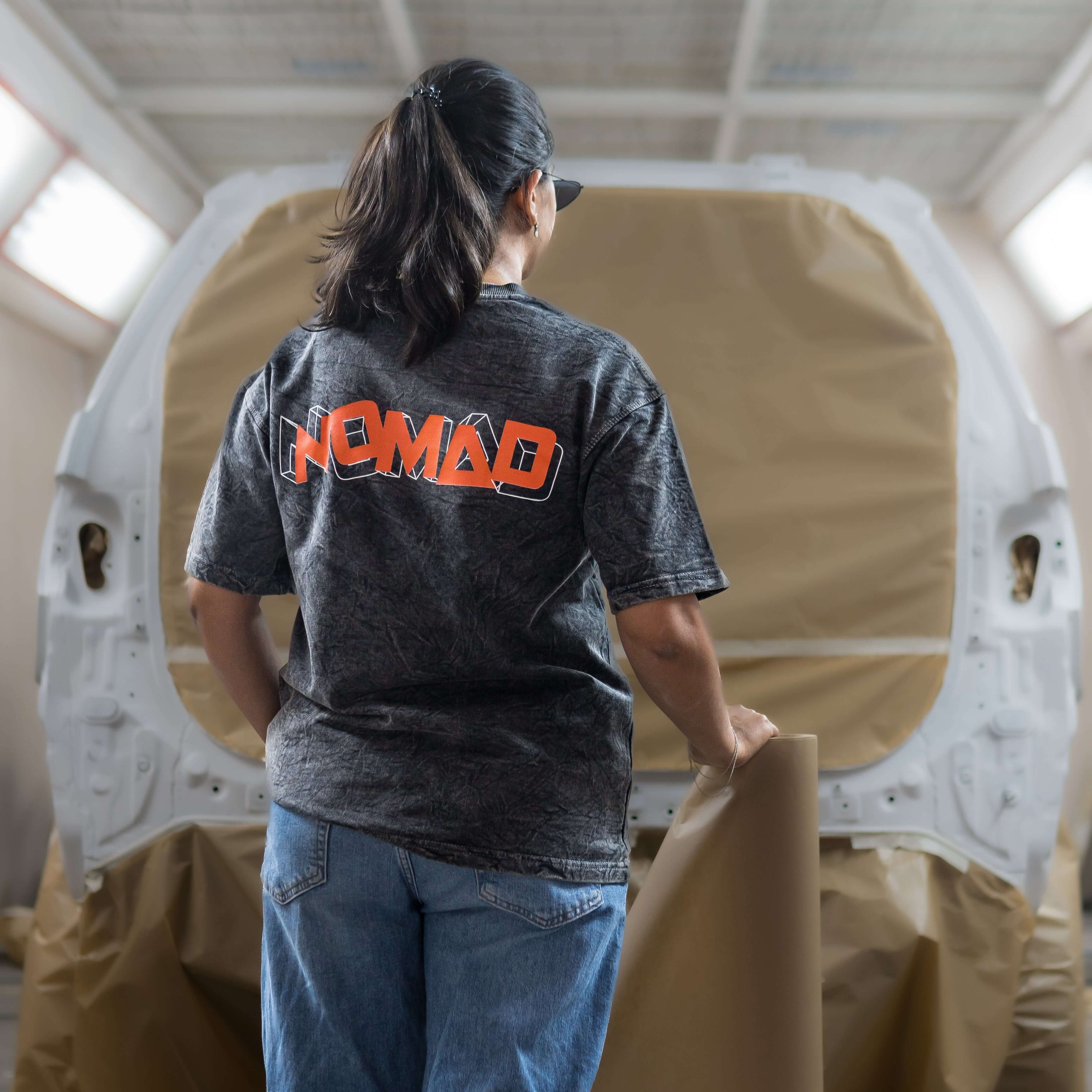 Women wearing a 'Nomad' acid wash t-shirt in a workshop setting